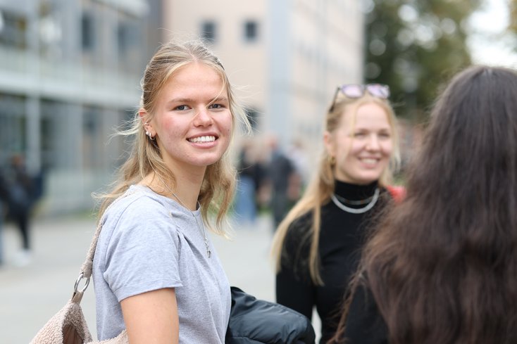Studentin lächelt in die Kamera.