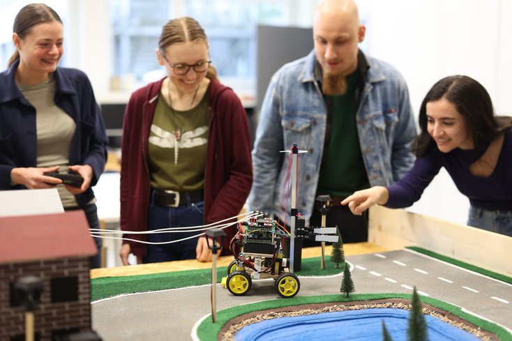 Foto: Studierende mit Roboter
