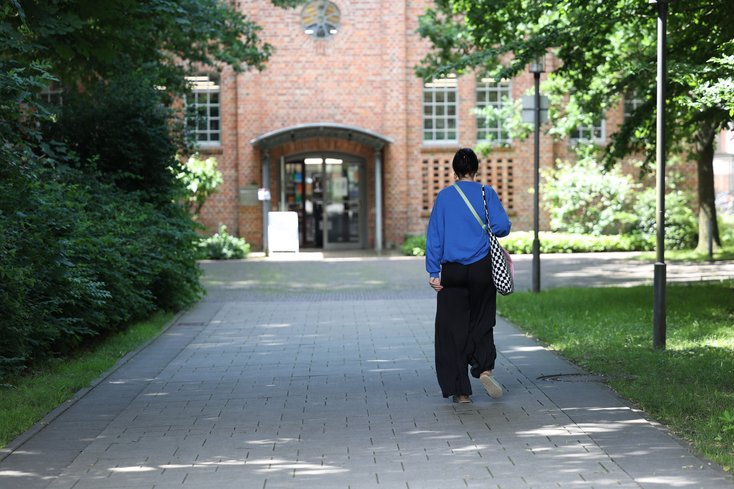 Studentin geht zur Bibliothek.