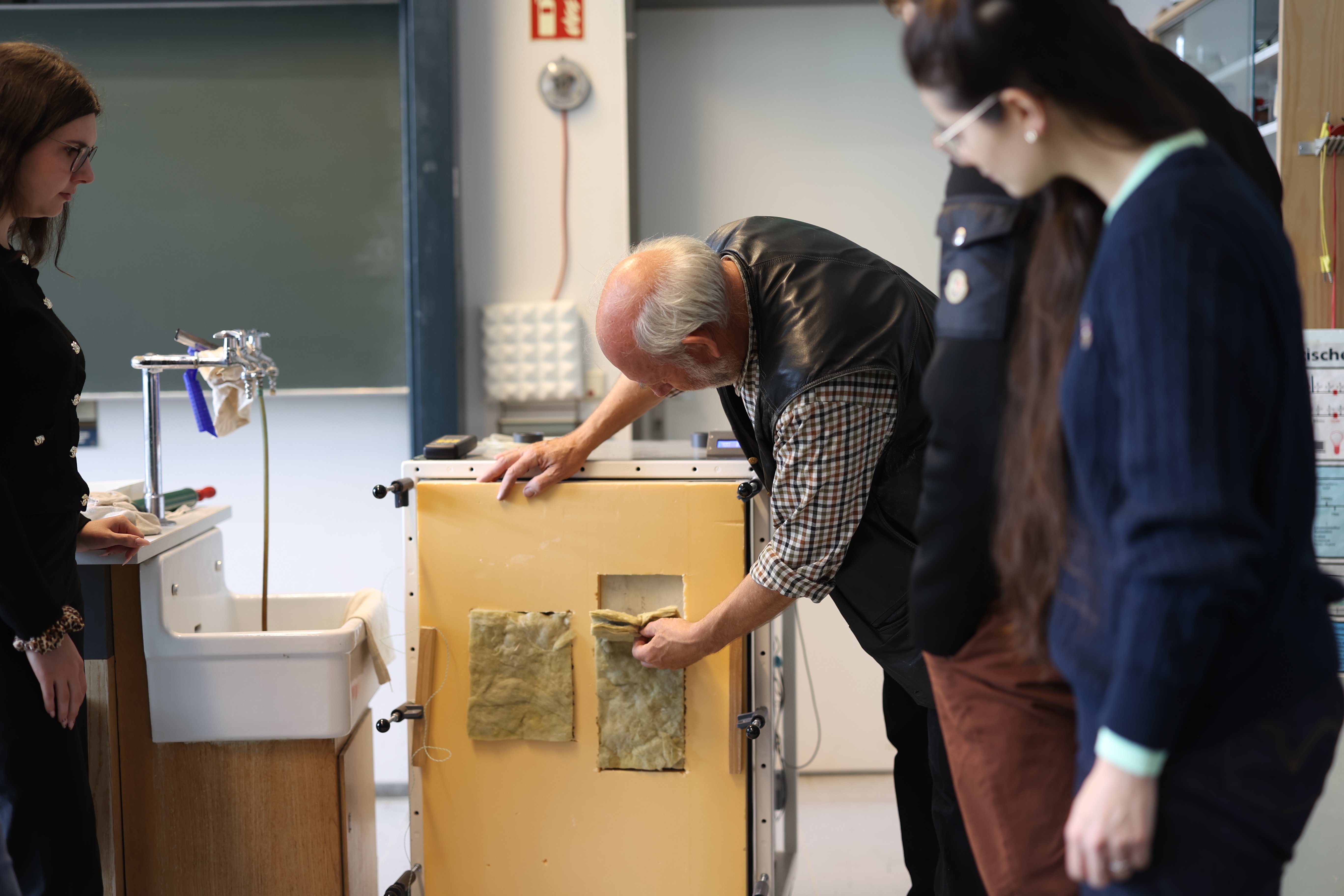 Dozent führt Physikexperiment durch.