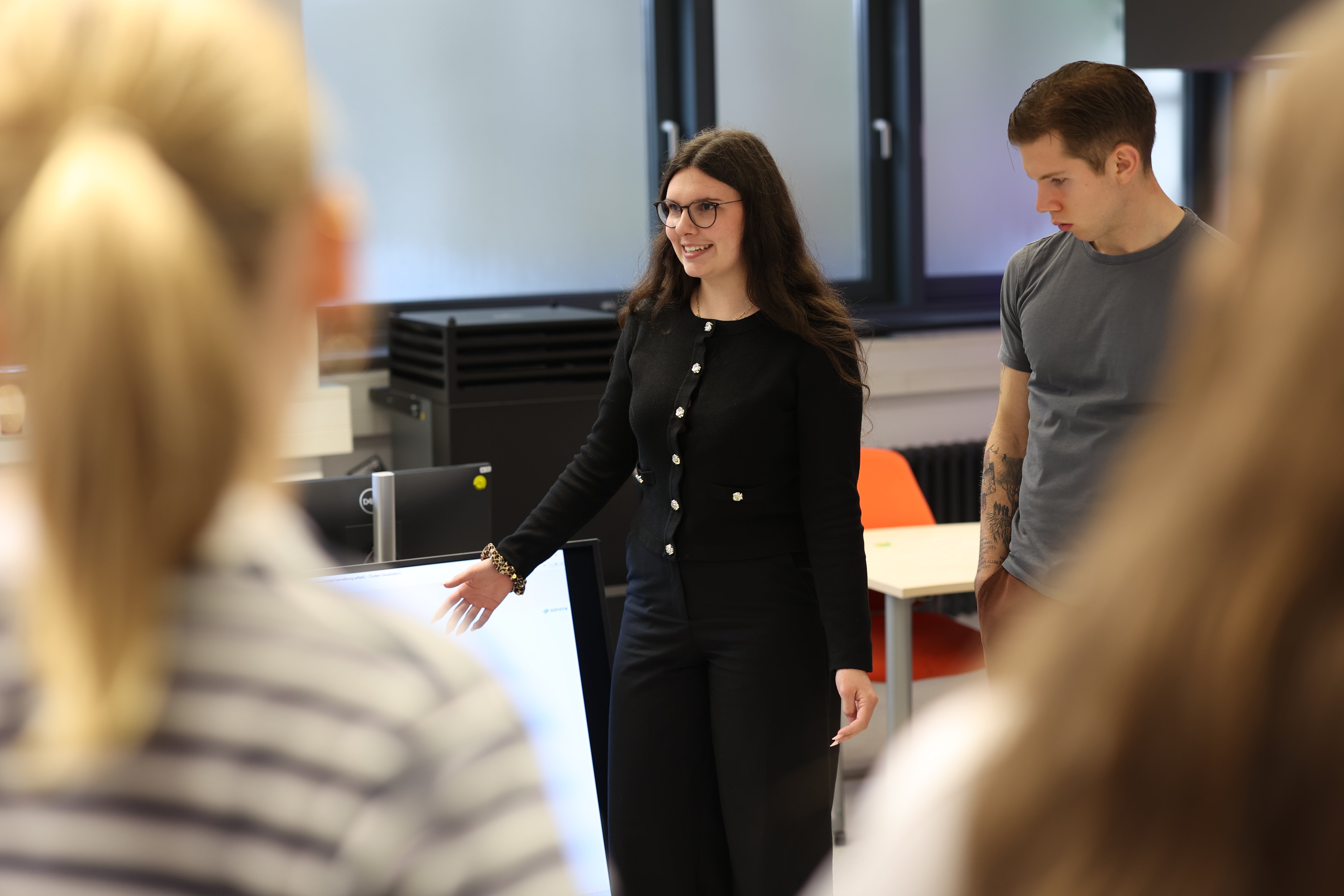 Studentin  erklärt ihrem Kommilitonen etwas.