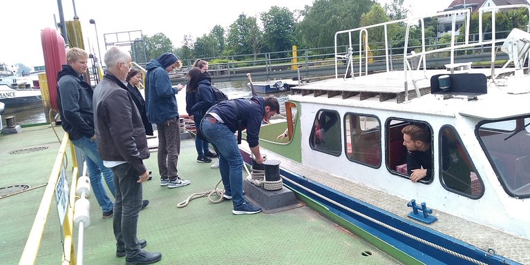 Studierende stehen vor der Schulungsbarkasse ALK.