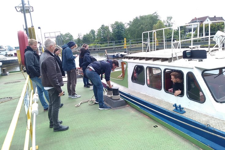 Studierende stehen vor der Schulungsbarkasse ALK.