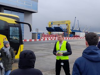 Hafenmitarbeiter erklärt den Studierenden etwas.