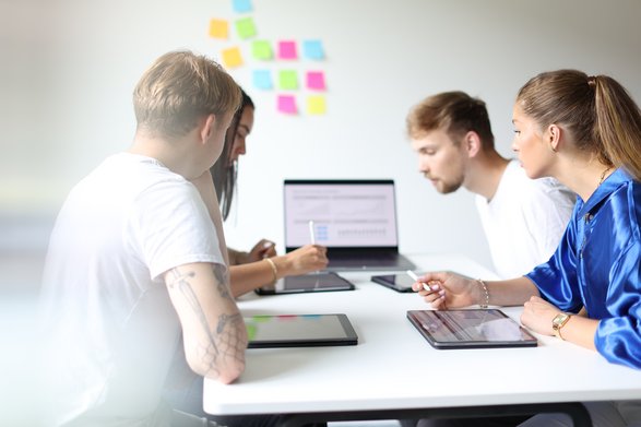 Studierende sitzen am Tisch und erarbeiten ein Konzept