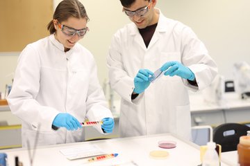 Zwei Studierende führen ein biologisches Experiment durch.