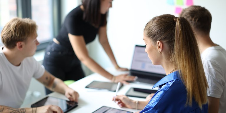 Studierende sitzen am Tisch und erarbeiten etwas.
