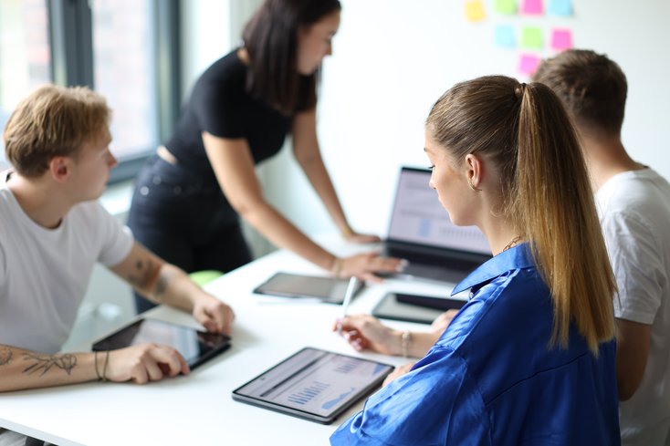Studierende sitzen am Tisch und erarbeiten etwas.