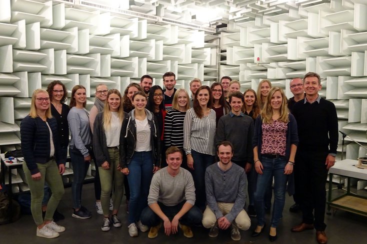 Friederike Horand (Leiterin der Abteilung Akustik und Thermodynamik und H+A Absolventin, vorne rechts) begrüßt eine Gruppe der jetzigen Studierenden mit den begleitenden Professoren (Jörg Bitzer, hinten 2.v.re. und Matthias Blau, rechts außen).