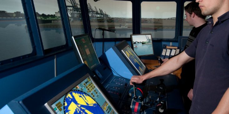 Studenten stehen auf der Brücke im Schiffsführungssimulator