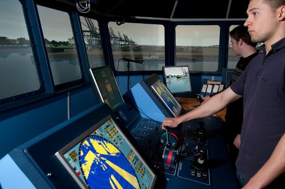 Studenten stehen auf der Brücke im Schiffsführungssimulator
