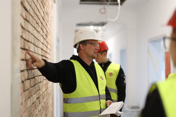 Bauleiter erklärt etwas.