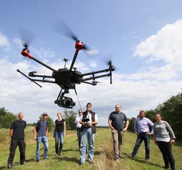 Mehrere Personen lassen Drohne für eine Vermessung fliegen