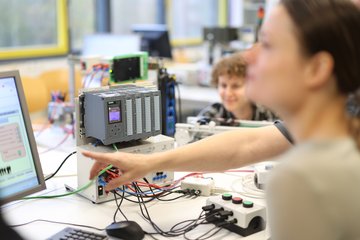 Studierende arbeiten in einem technischen Labor.