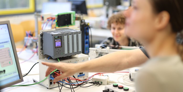 Studierende arbeiten in einem technischen Labor.