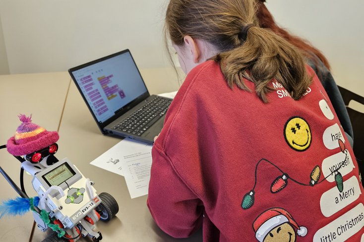 Zwei Schülerinnen programmieren einen Roboter