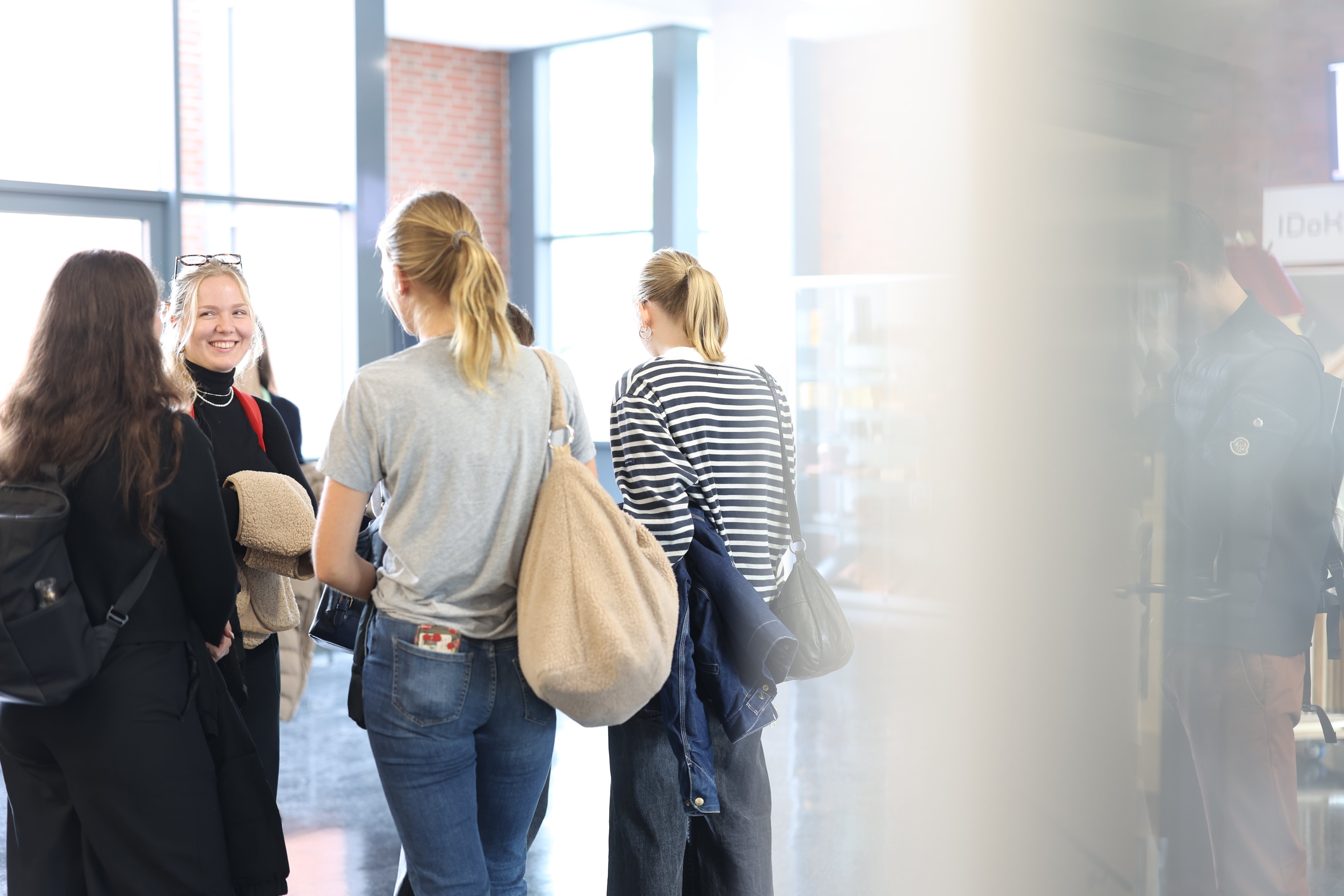 Gruppe Studierender unterhält sich auf dem Flur.