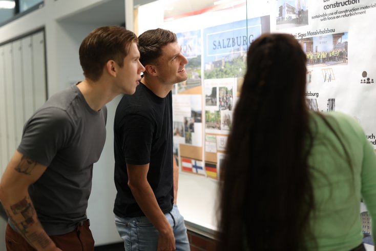 Studierende informieren sich über Poster.