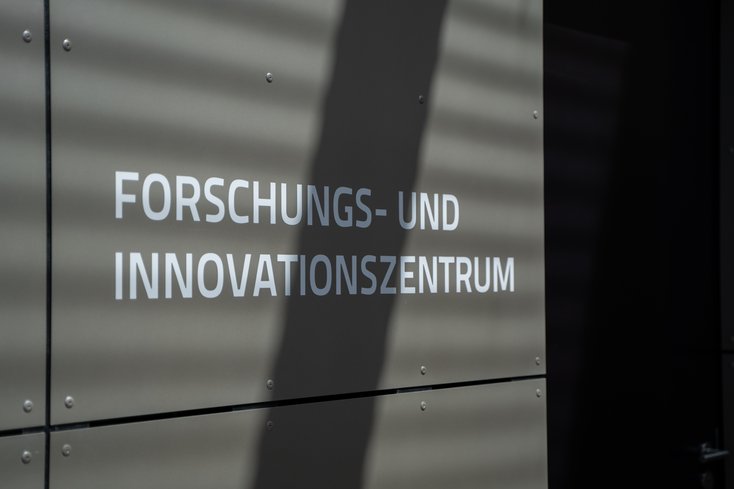 Eine graue Hauswand mit der Aufschrift „Forschungs- und Innovationszentrum"