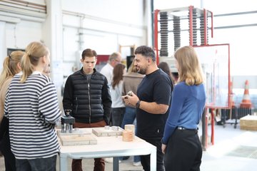 Dozent erklärt Studierenden etwas in der Materialprüfanstalt.