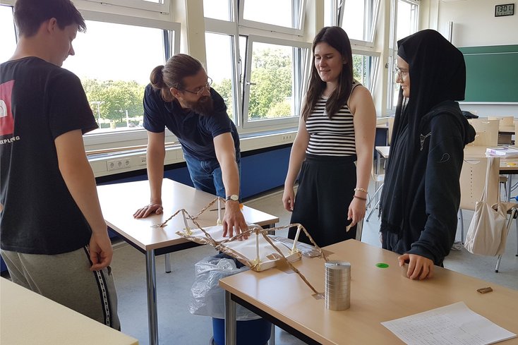Schüler_innen testen die Tragfähigkeit einer selbst gebauten Brücke beim Workshop zum Thema "Leichtbau" (Foto: Anka Albrecht, Jade HS)