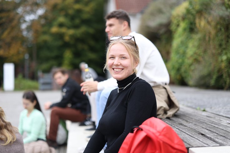 Studentin lächelt in Kamera.