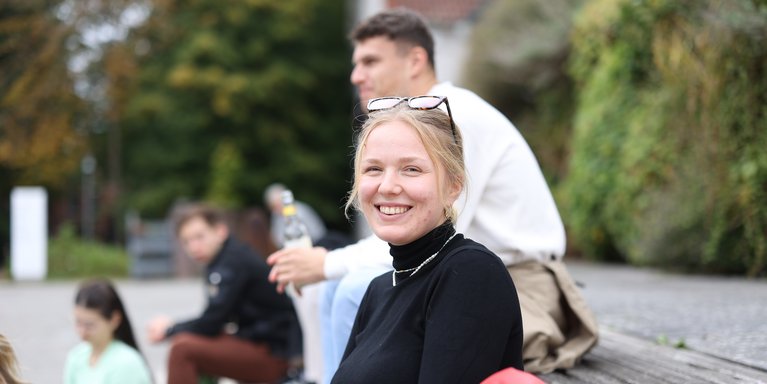 Studentin lächelt in Kamera.