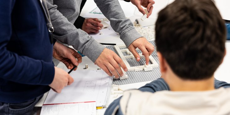 Schüler bauen mit Lego ein Haus