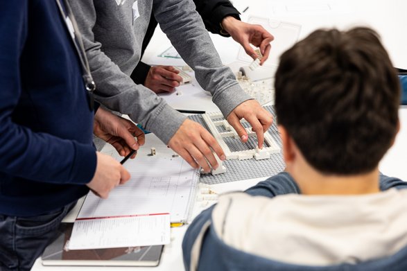 Schüler bauen mit Lego ein Haus