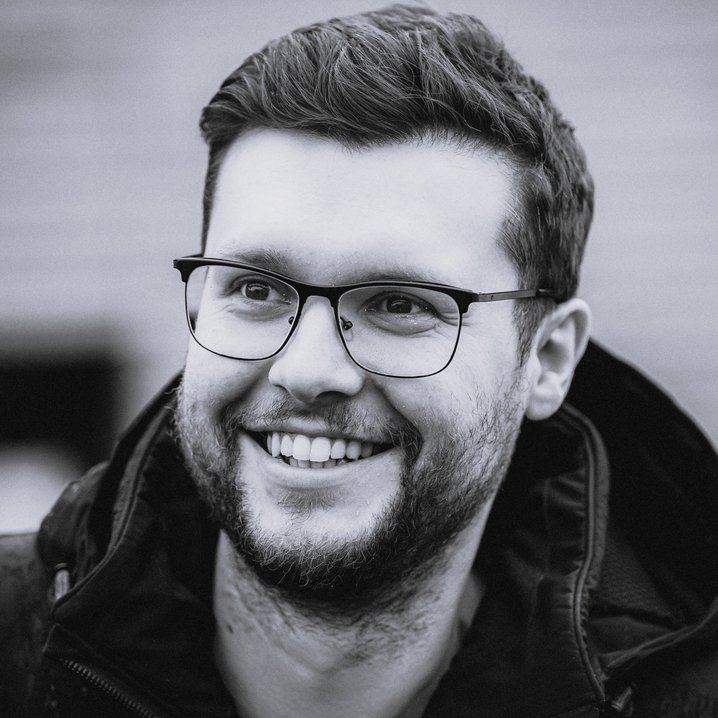 Porträtaufnahme eines Mannes mit dunklen Haaren und Brille