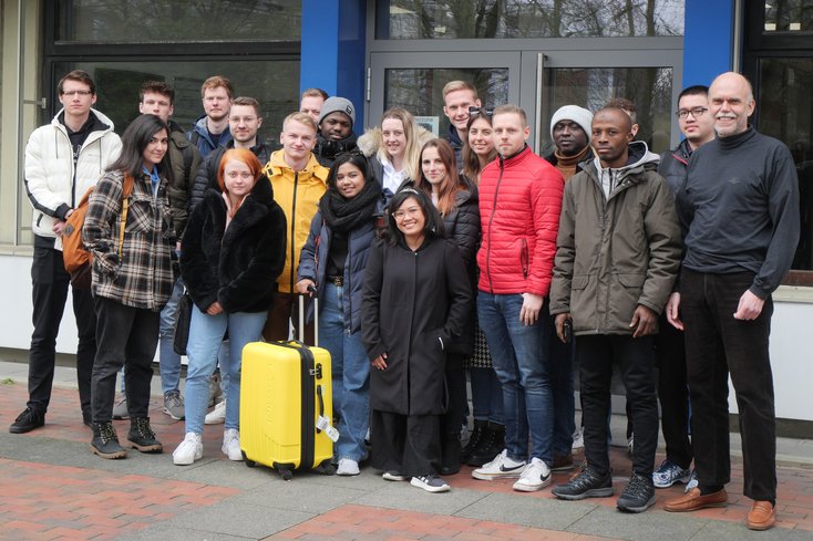 Studierende der Jade Hochschule und der Partnerhochschulen aus Finnland, der Slowakei und den Niederlanden zusammen mit Projektleiter Prof. Dr. Hardy Oepping (re.) vor dem Westgebäude am Campus Wilhelmshaven. (Foto: Daniela Wrage/Jade HS)