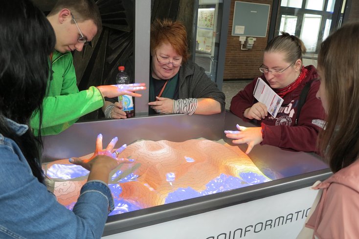 Beim Augmented Reality Sandkasten spielte zu mindestens virtuelles Wasser eine Rolle. In die geschaffene Sandlandschaft lassen es die Besucher durch gespreizte Hände regnen.
