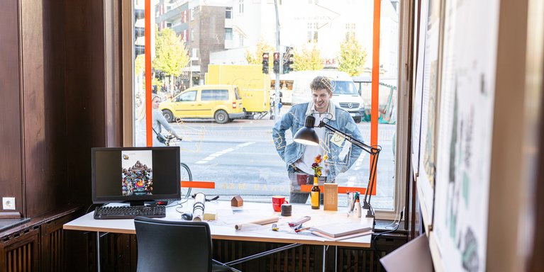Eine Person schaut durch ein Fenster in einen Ausstellungsraum