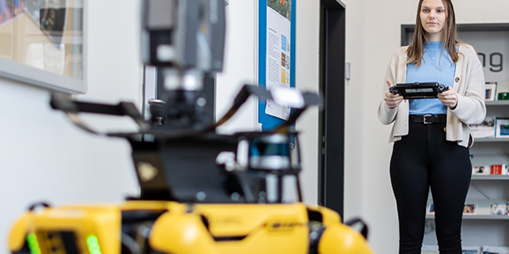 Person steuert einen Roboter