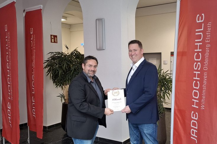 Dekan Prof. Dr. Thomas Kirsch gratuliert Prof. Dr. Frank Wallhoff zum 25. Dienstjubiläum. (Foto: Jade HS)