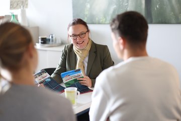 Dozentin berät zwei Studierende.