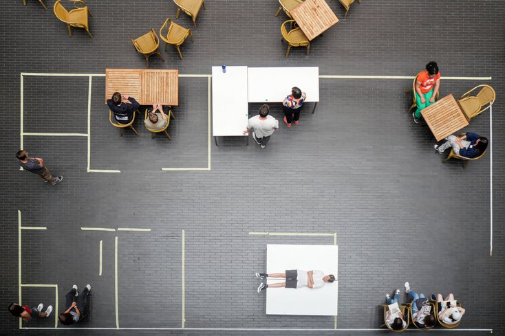 Workshopteilnehmer haben einen Wohnungsgrundriss mit Kreppband auf den Boden angebracht