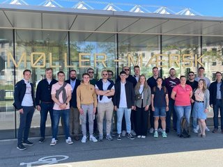 Studierende stehen vor einem Firmengebäude