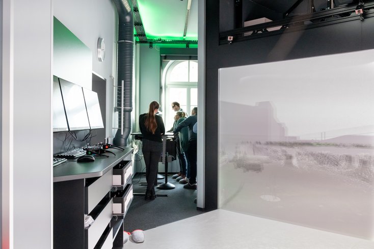 Eine Personengruppe sieht sich eine Demonstration im Labor für Digitales Engineering an.