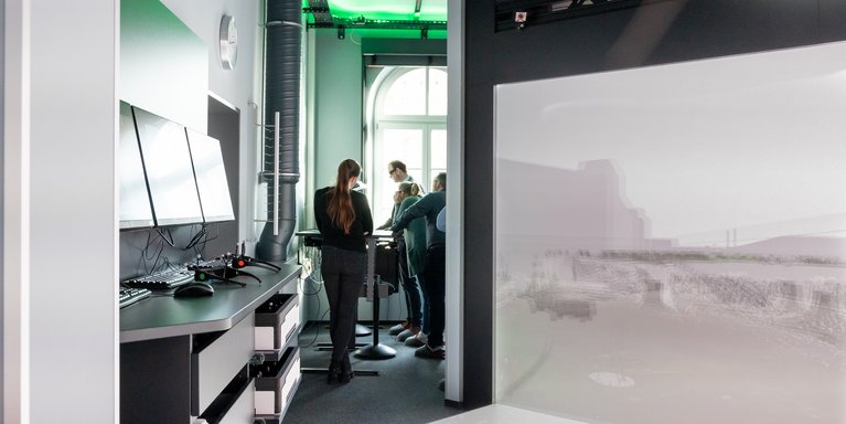 Eine Personengruppe sieht sich eine Demonstration im Labor für Digitales Engineering an.