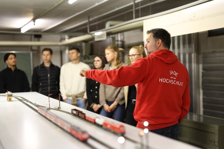Dozent erklärt Studierenden das Eisenbahnlabor.