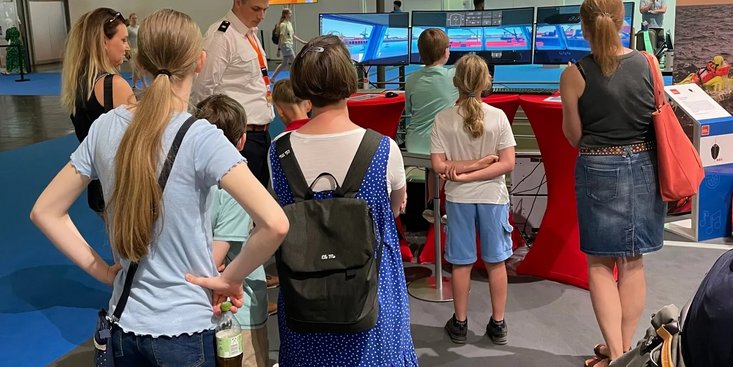 Besucher der IdeenExpo stehen an dem Schiffsführungssimulator an.