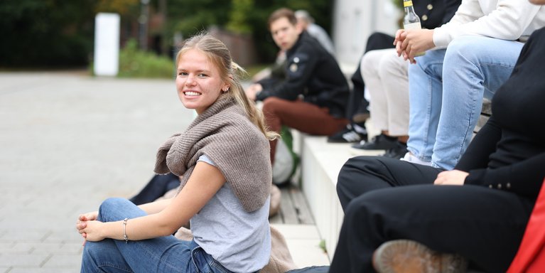 Studentin lächelt in Kamera.
