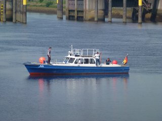 Blaues Motorboot auf dem Wasser, auf dem 4 Studierende arbeiten.