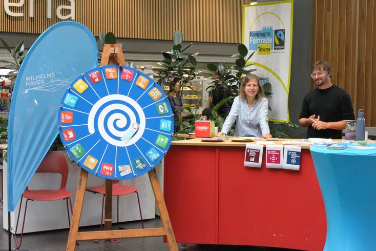 Stand der „Fairtrade Town Wilhelmshaven” mit Mitgliedern der Steuerungsgruppe: Juliane Heimann (Wirtschaftsförderungsgesellschaft Wilhelmshaven mbH) und André Lachmund (Stadt Wilhelmshaven) (Bild: Jade HS/Berit Müller)