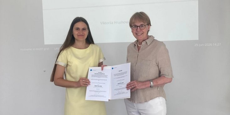 Der Preisträgerin wird die Urkunden überreicht.