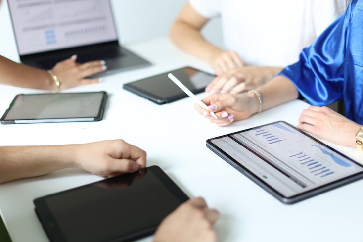 Tablets auf Tischplatte mit Grafiken