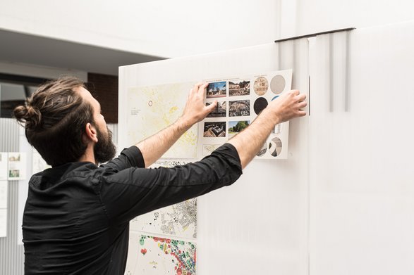 Ein Student hängt einen Architekturplan auf