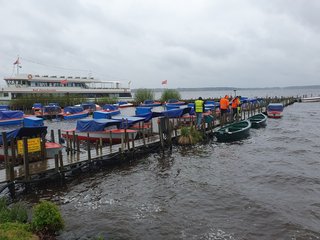 Studierende stehen auf Steg und messen die Gewässertiefen mit Lotstab und GNSS