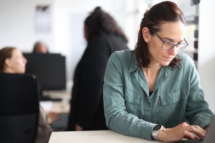 Junge Frau ist am Laptop vertieft.
